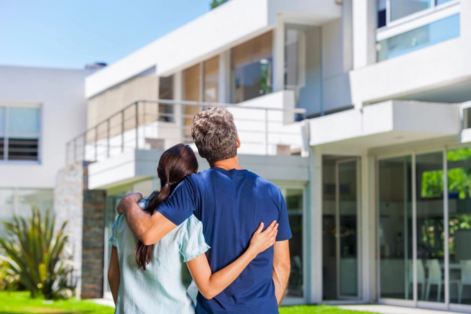 A couple of people that are standing in front of a house